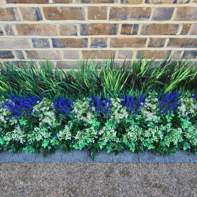 A flower bed filled with artificial plants and foliage.