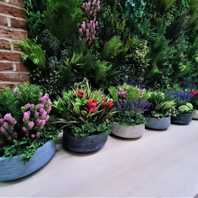 Pots and planters filled with mixed artificial flowers and plants