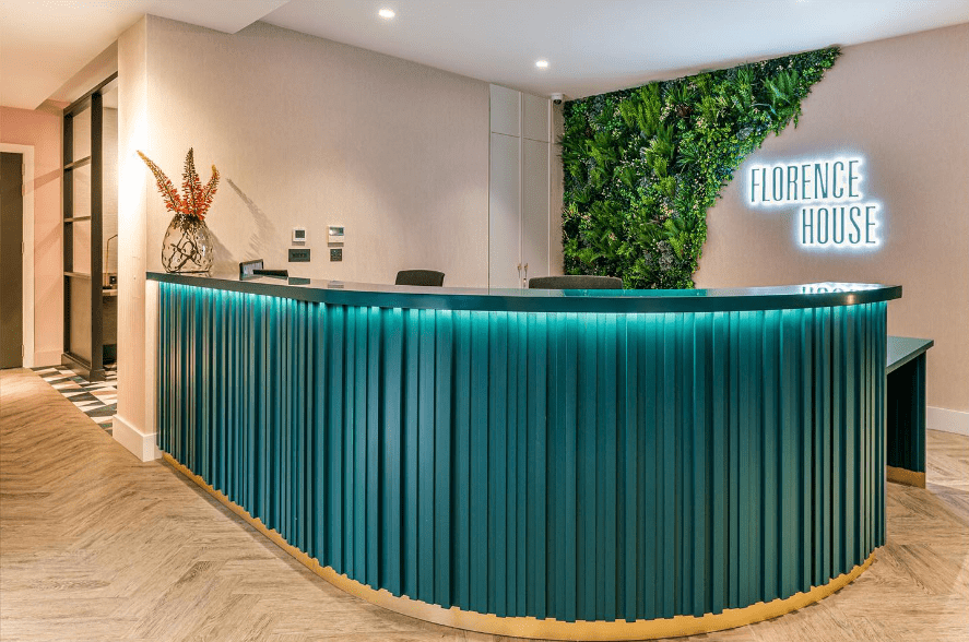 Artificial green wall behind a reception desk in an apartment block.