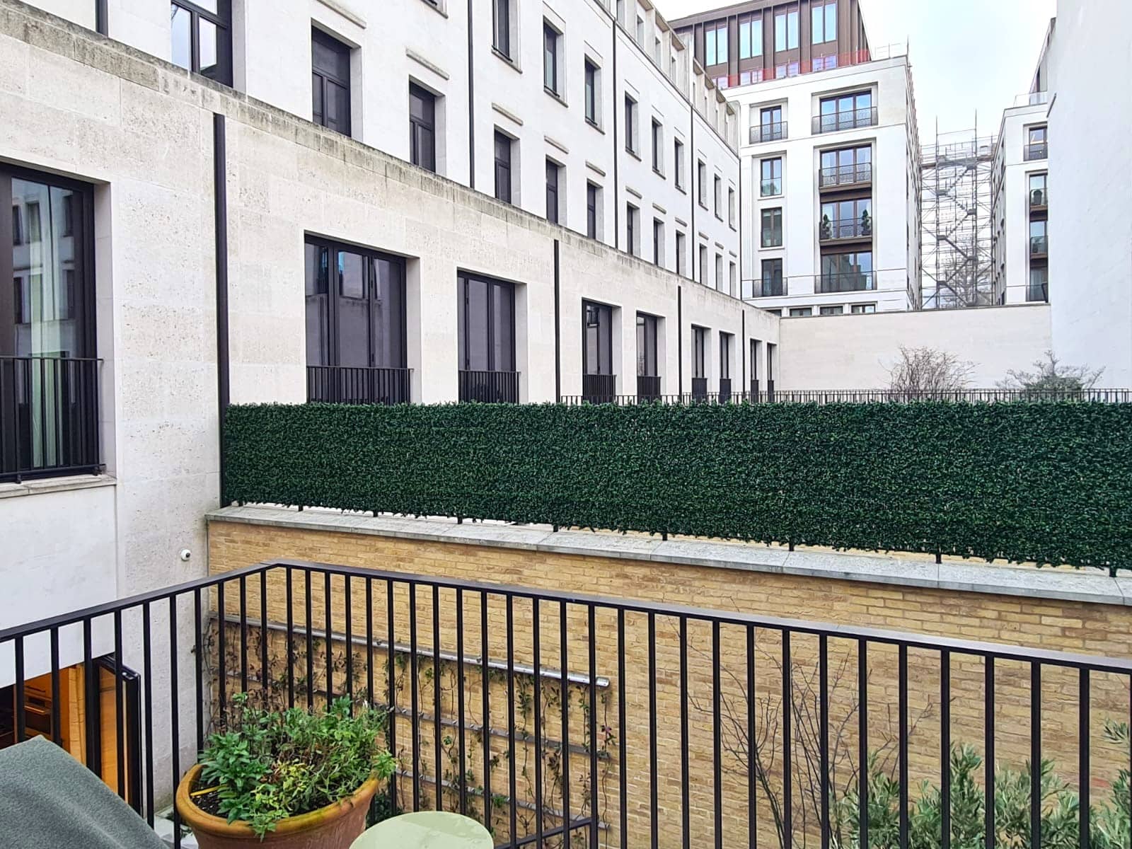 An installation of artificial boxwood panels on railings in a garden