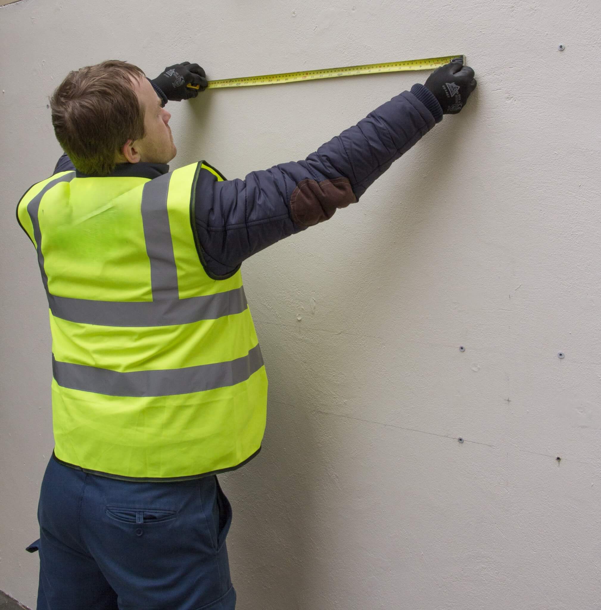 Vistafolia measuring wall prior to installing artificial green wall